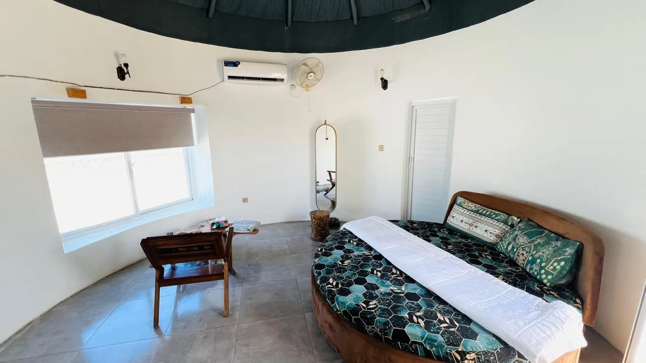 Interior of luxury room featuring modern and comfortable king size bed, furniture and window view of the ormara beach