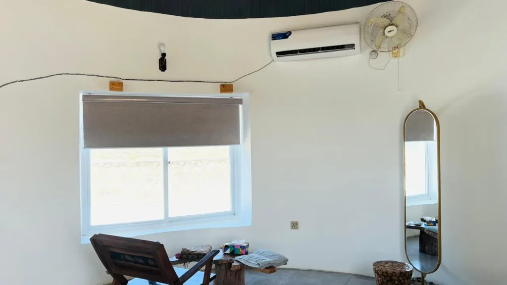 Interior of luxury room featuring modern and comfortable king size bed, furniture and window view of the ormara beach