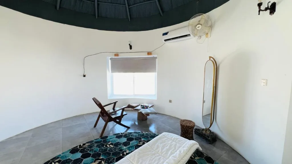 Interior of luxury room featuring modern and comfortable king size bed, furniture and window view of the ormara beach