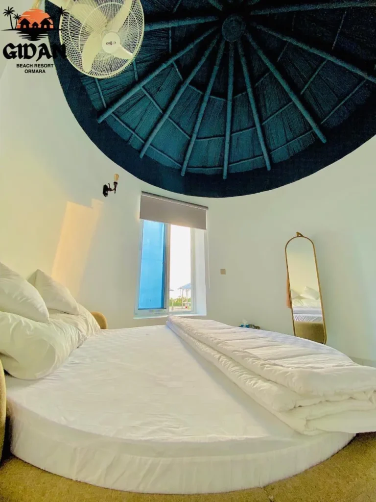Interior image of gidan beach resort couple room, featuring comfortable bed and sea view from window.