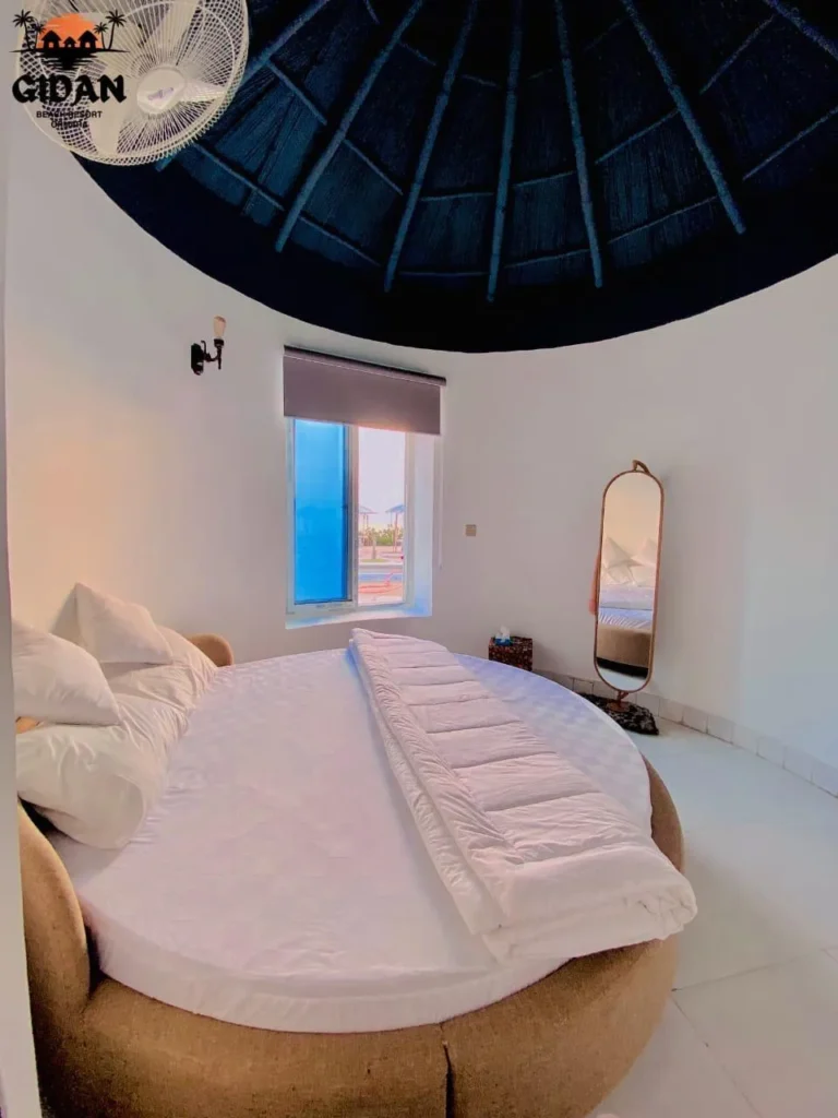 Interior image of gidan beach resort couple room, featuring comfortable bed and sea view from window.