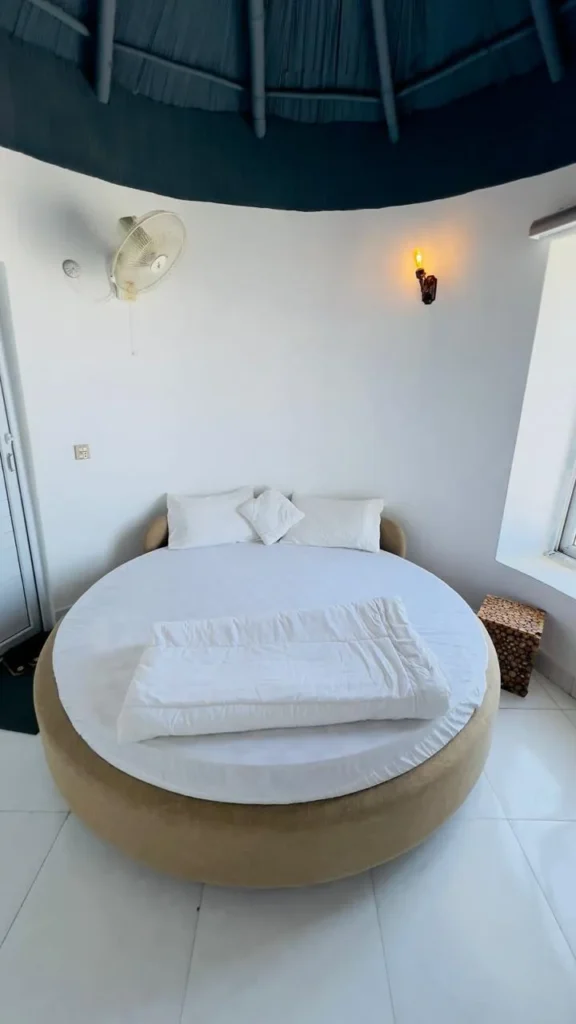 Interior image of gidan beach resort couple room, featuring comfortable bed and sea view from window.