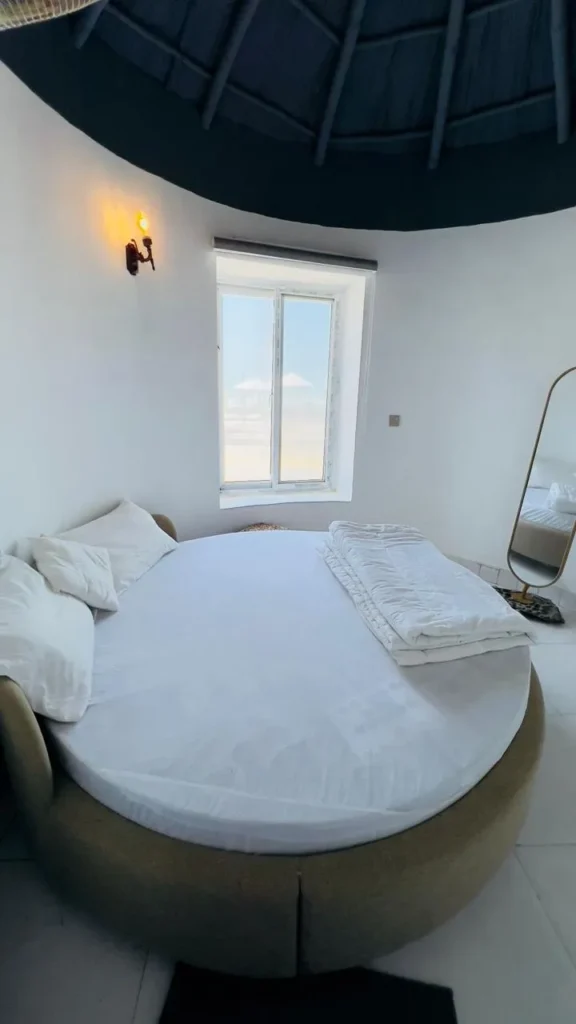 Interior image of gidan beach resort couple room, featuring comfortable bed and sea view from window.